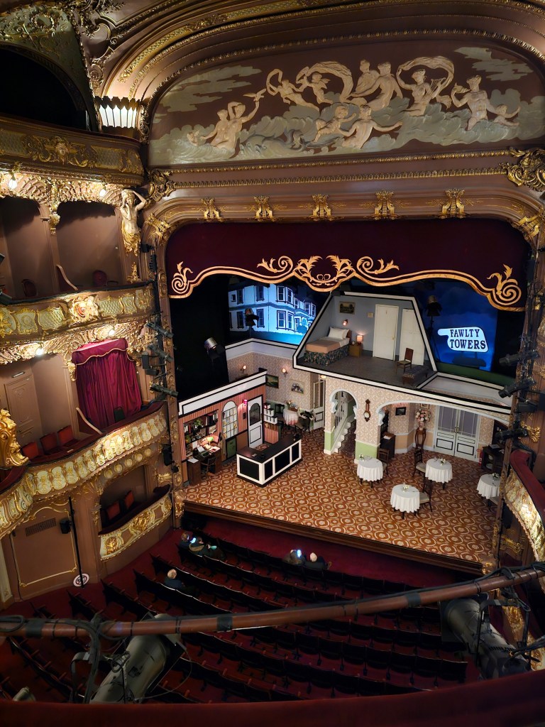 The inside of Apollo Theatre in West End, London. The scene has props for the Fawlty Towers play.