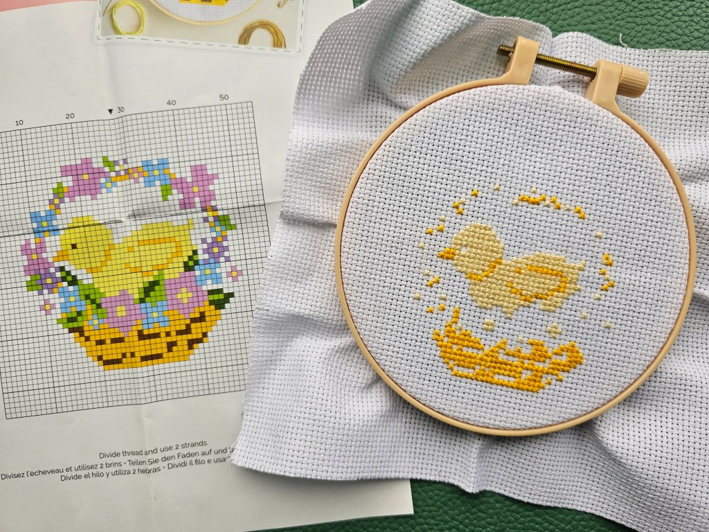 Partially completed cross stitch project. The yellow chick and the basket are done.
