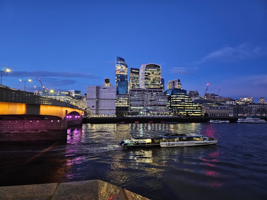 The City of London at night, seen from across the Thames.