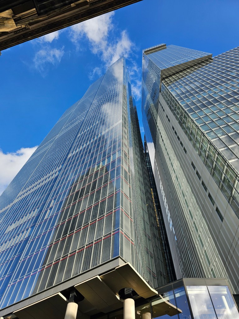Skyscrapers in the City of London viewed from the ground. Blue skies in the background.