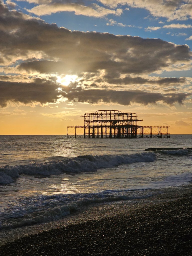 Sunset in Brighton, UK. The sun is behind the old pier.