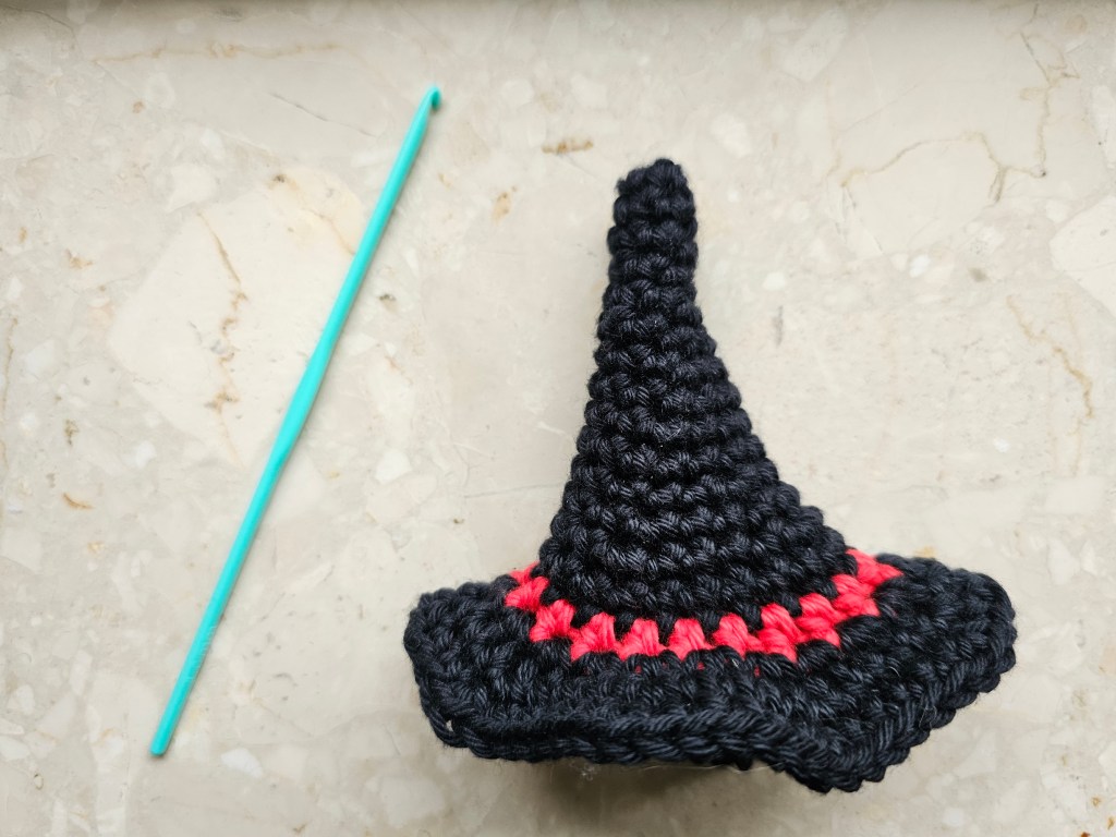 Black crocheted small witch's hat with a red stripe