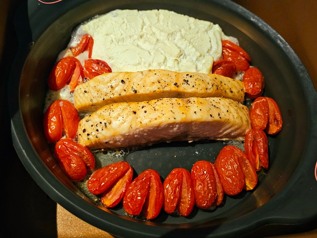 Salmon fillets, cream cheese and cherry tomatoes, after baking.