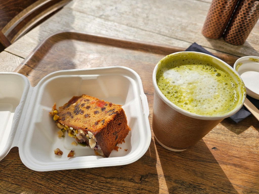 A slice of fruitcake and a cup of matcha latte