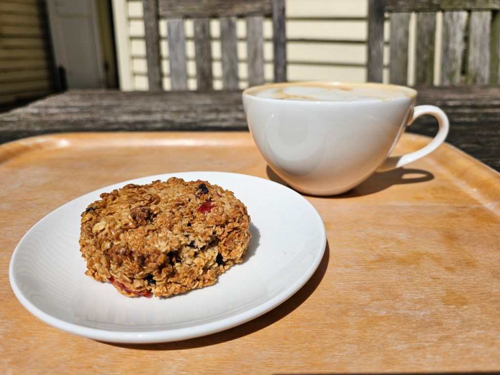 A large cup of coffee and a piece of flapjack.