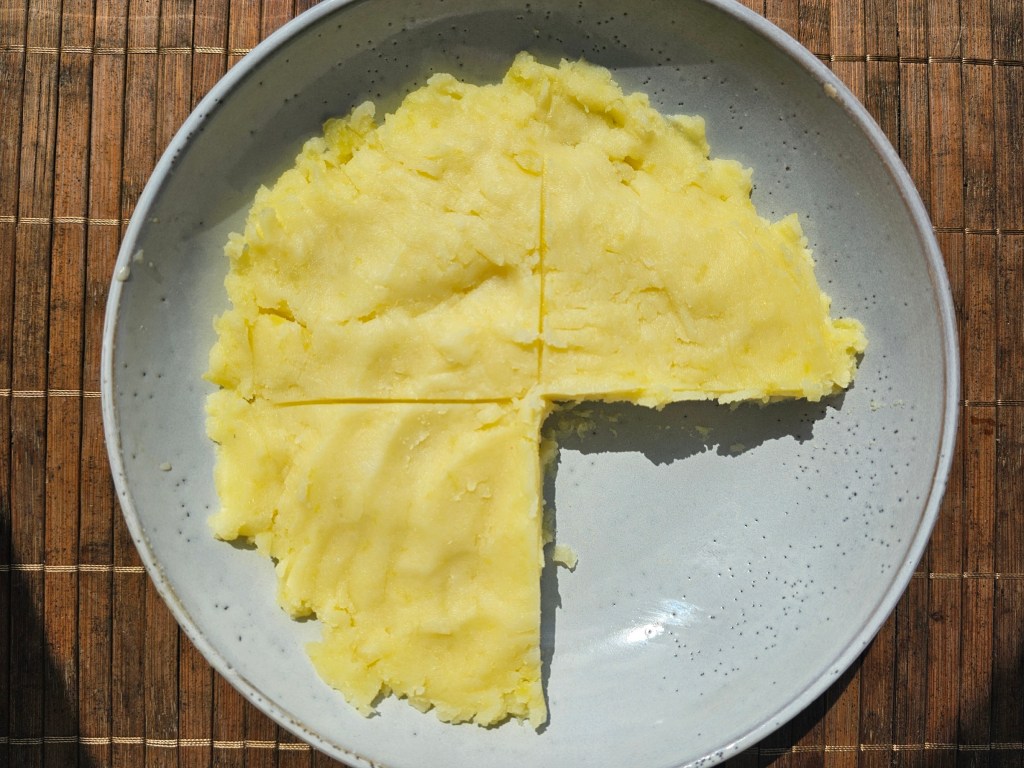 A plate with mashed potatoes covering 3/4 of the plate. The remaining 1/4 of the plate is empty.