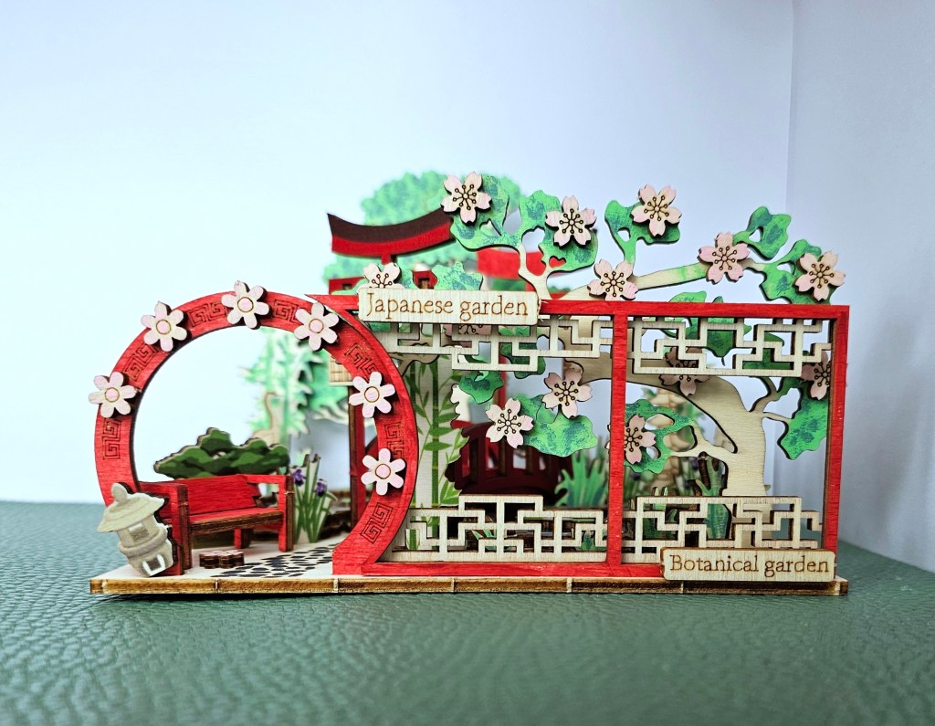 Completed plywood scene featuring a Japanese garden with a pond with koi fish.