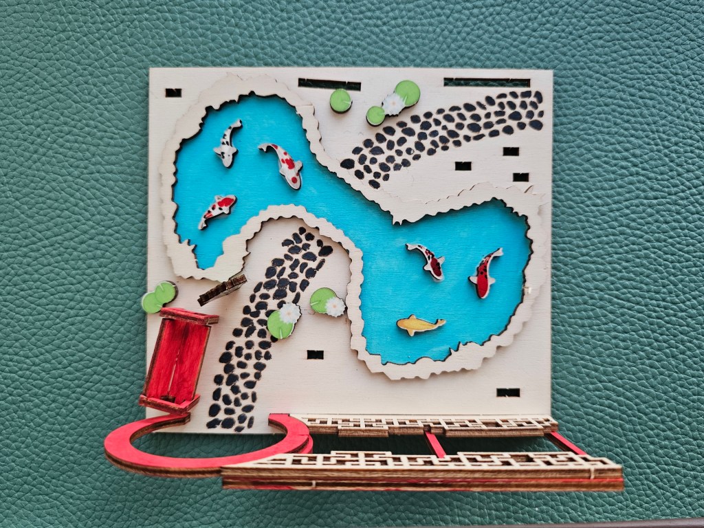 Some of the elements of the scene are glued in place. This includes part of the pond and the gate.