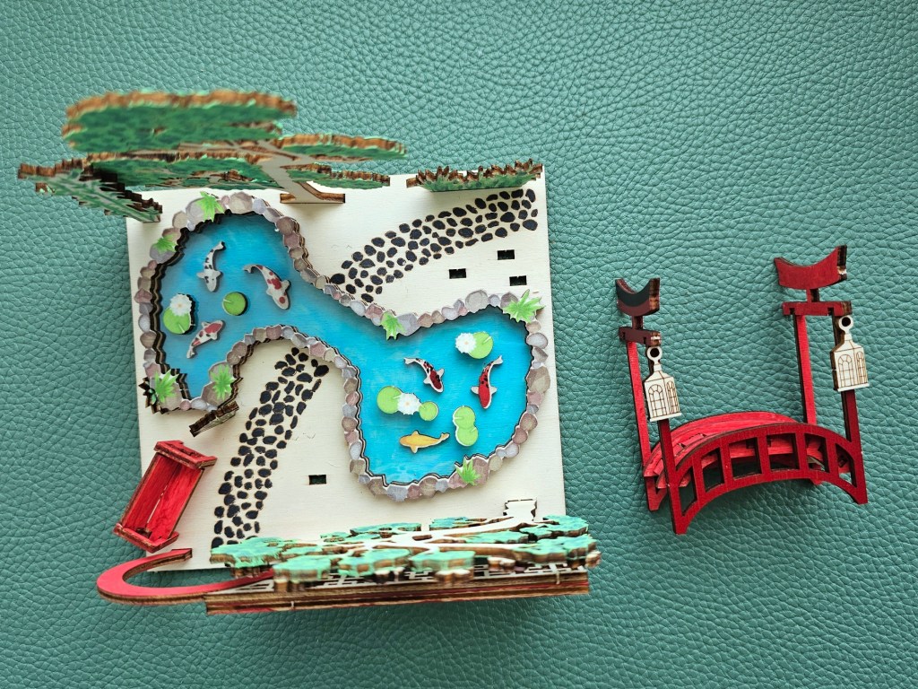 Some of the elements of the scene are glued in place. This includes the pond, the trees and the gate.