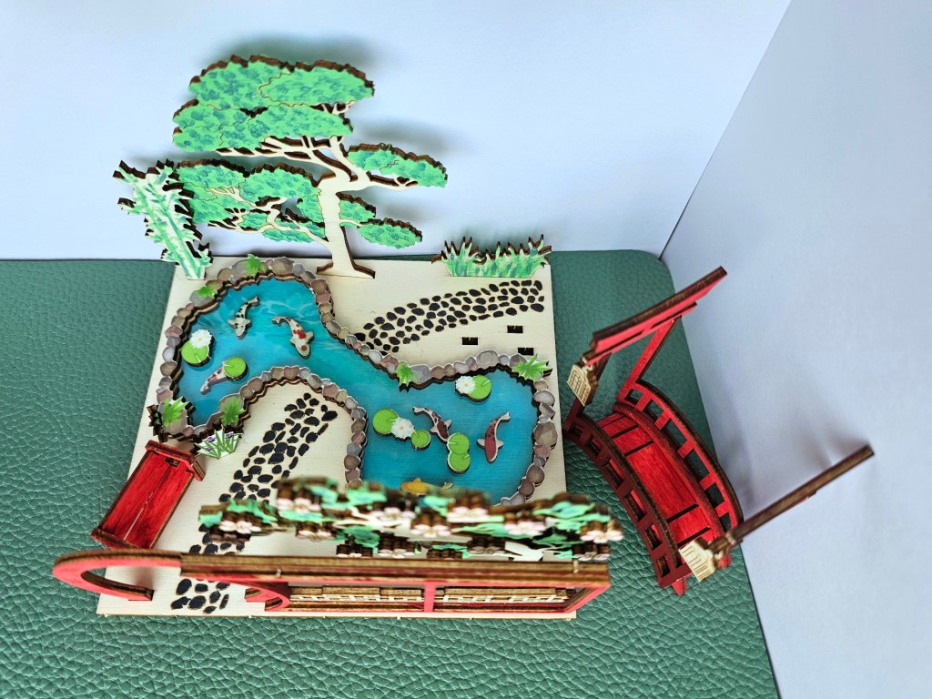 Some of the elements of the scene are glued in place. This includes the pond, the trees and the gate.