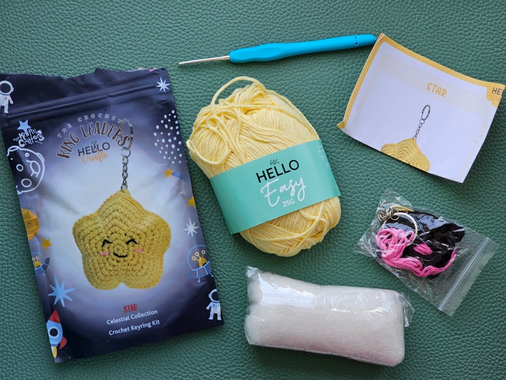 Contents of a DIY kit for making a crocheted star keyring.