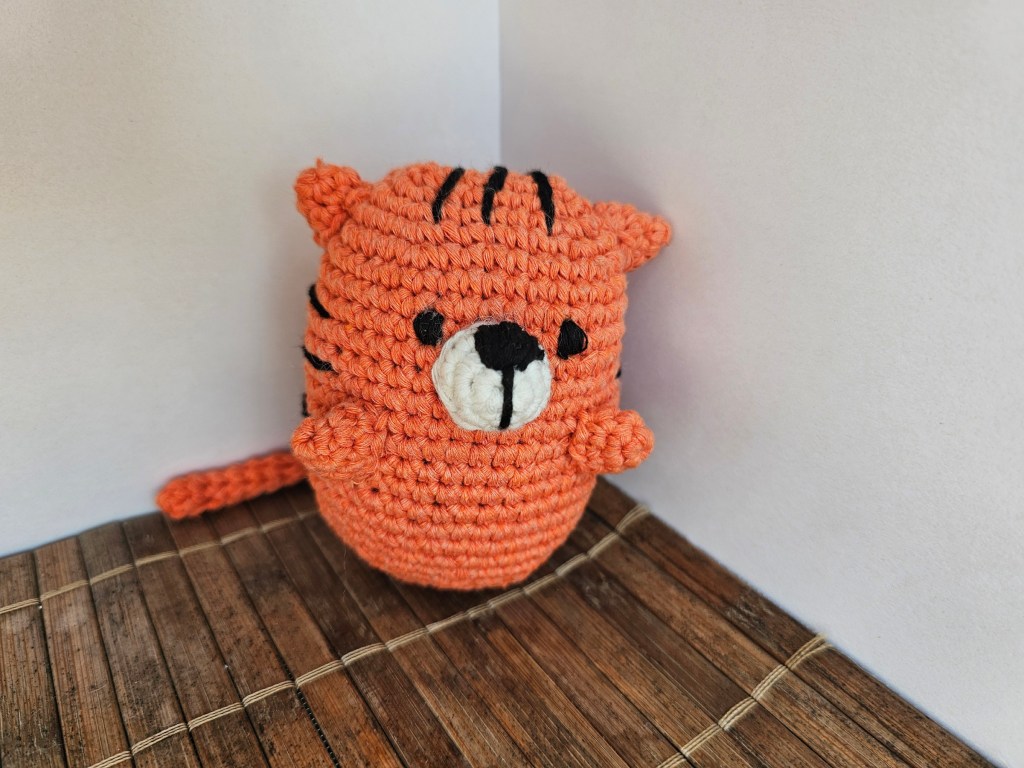 Completed crocheted amigurumi tiger plushie.