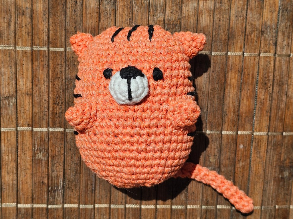 Completed crocheted amigurumi tiger plushie.