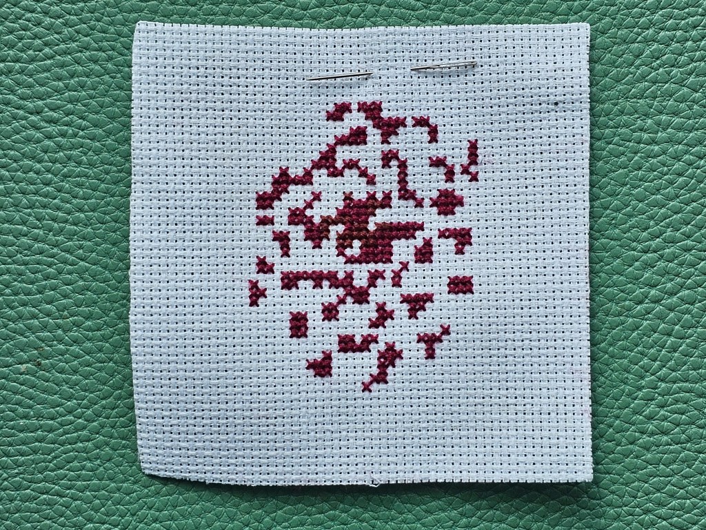 The first sewn cross stitches for a dahlia flower design
