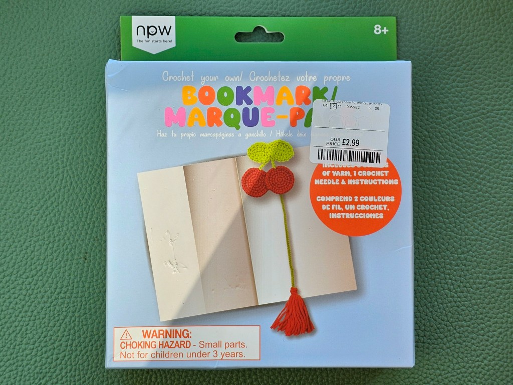 An assorted kit for making a crocheted bookmark with a cherry design.