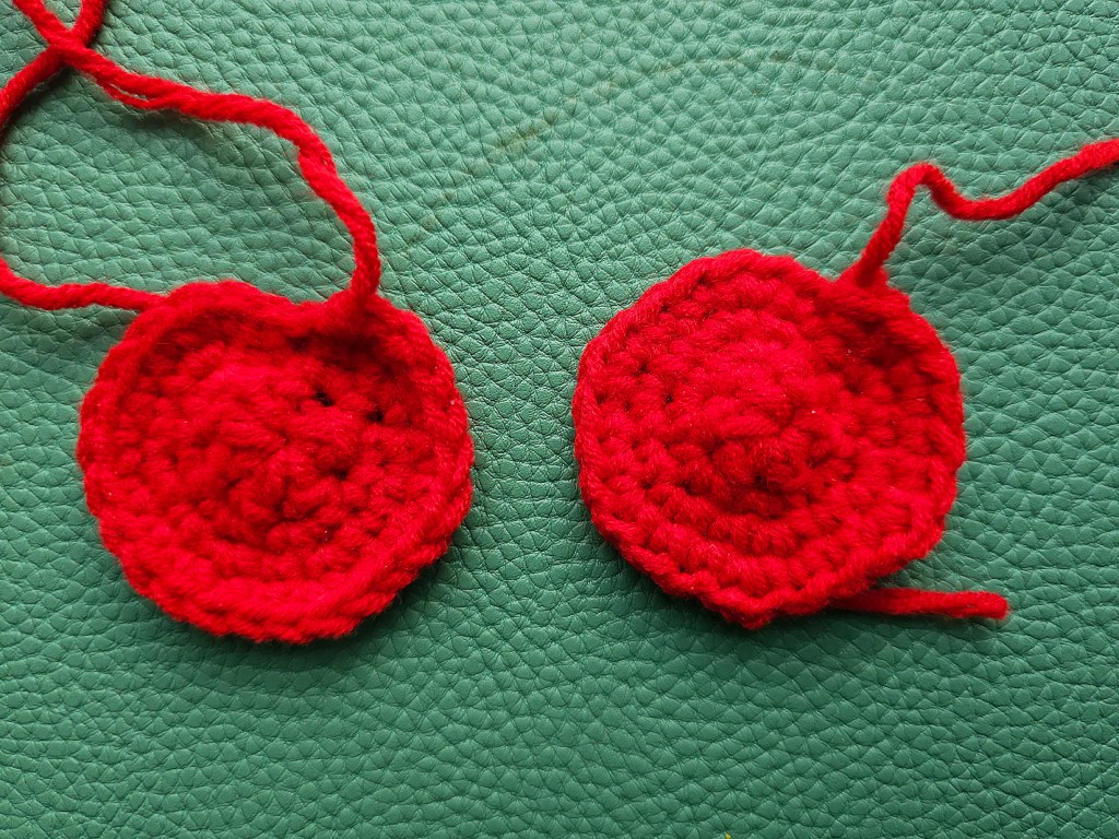 Two crocheted red cherries.