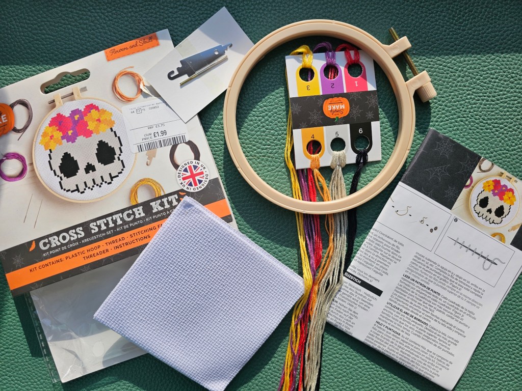 Contents of a mini cross stitch design with a skull with flowers Halloween design