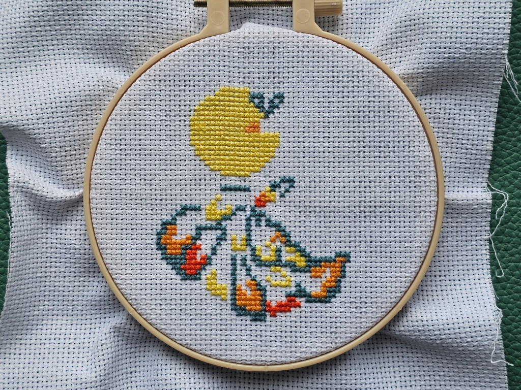 Partially completed mini cross stitch design featuring a peacock sitting on a branch