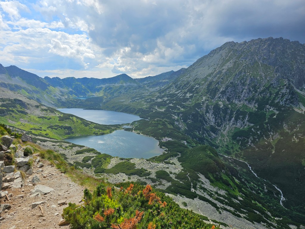 A panoramic view of a couple of large lakes surrounded by tall mountains