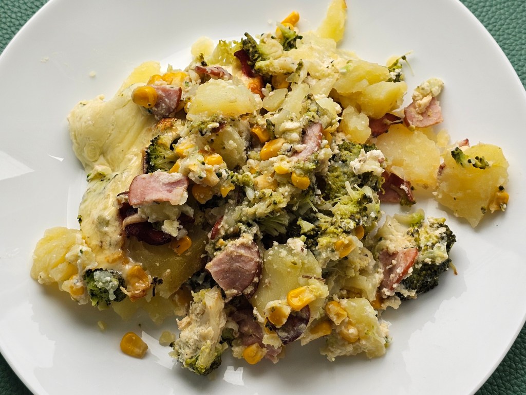 Cooked potato bake with broccoli, sweetcorn and ham, served on a plate