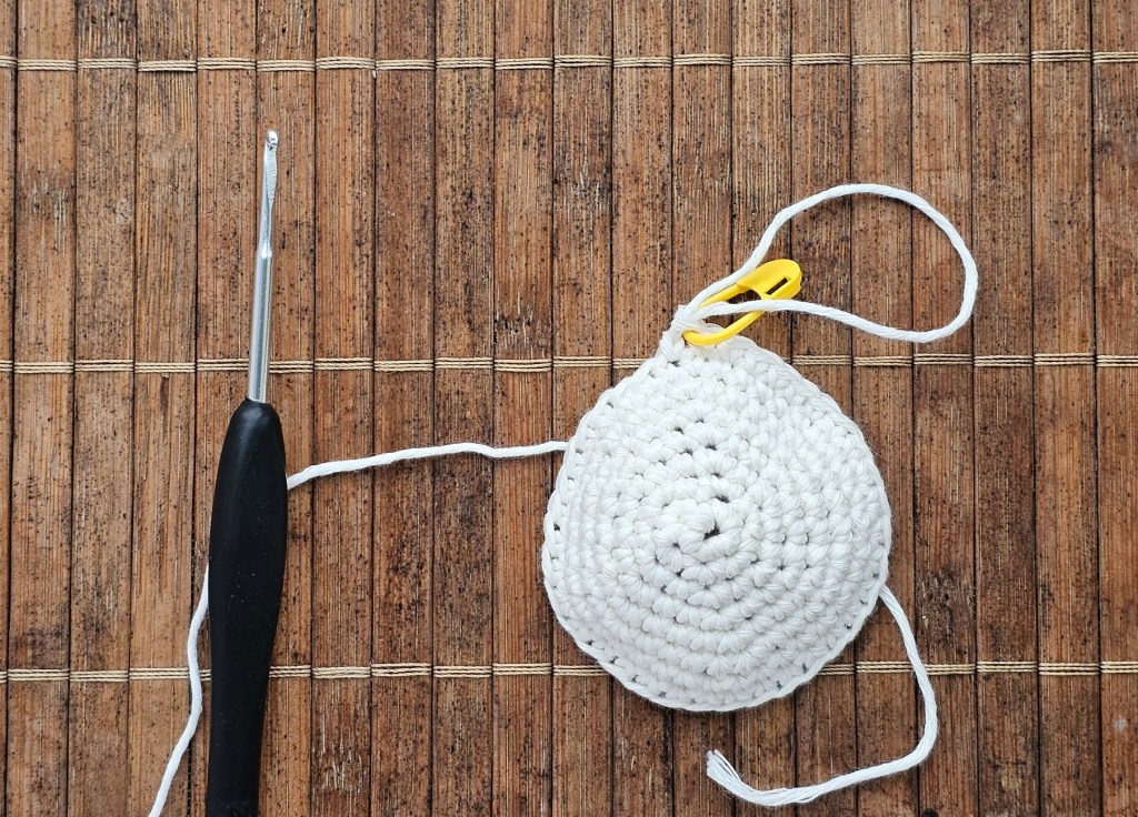 A white crocheted circle - the first few rounds of crocheting a small ghost.