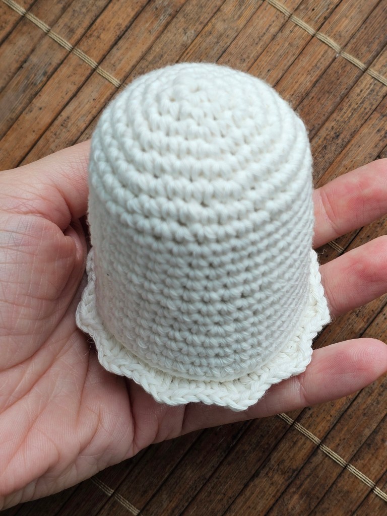 The body of a white crocheted ghost, with a frill at the bottom