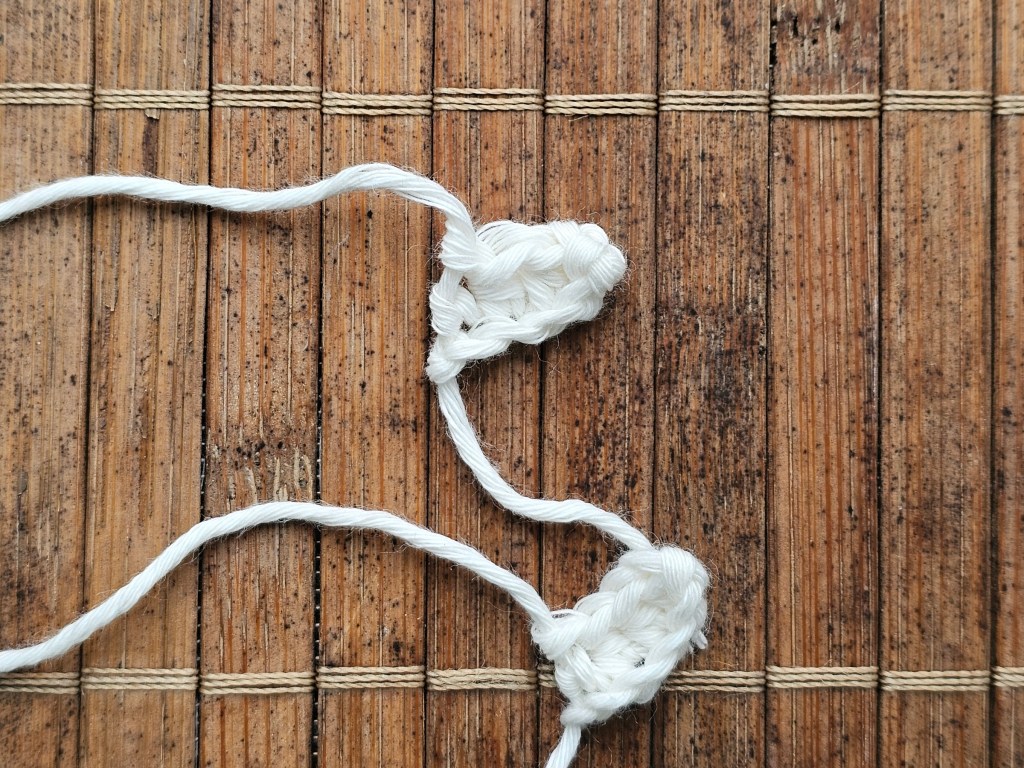 Two tiny arms crocheted from white yarn