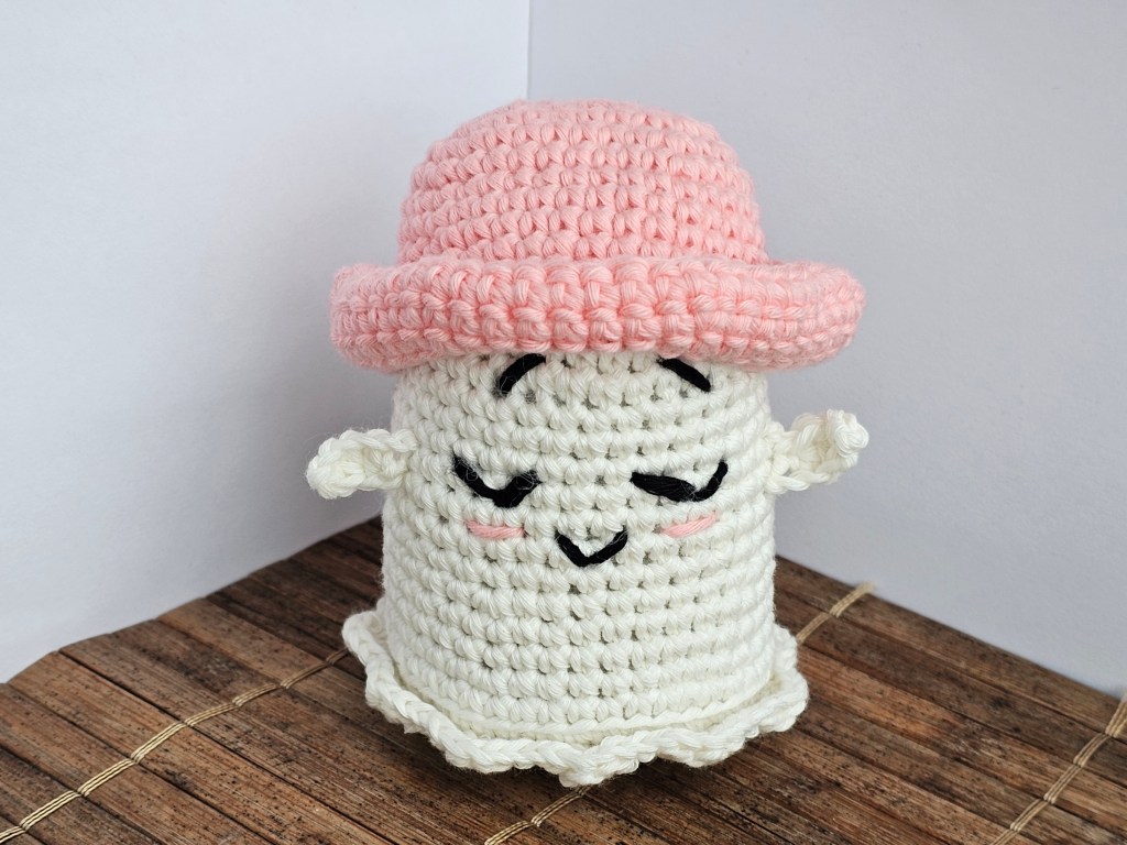 Finished crocheted tiny ghost with a pink bowler hat