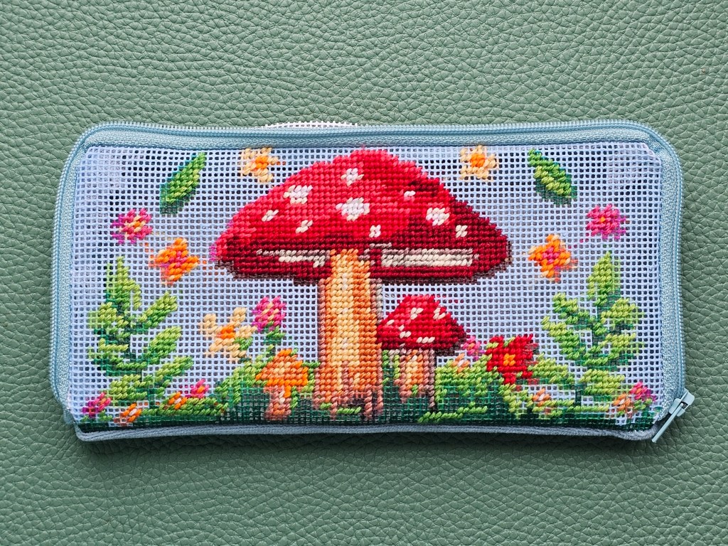 Nearly finished DIY zip case with a half stitch design featuring colourful mushrooms