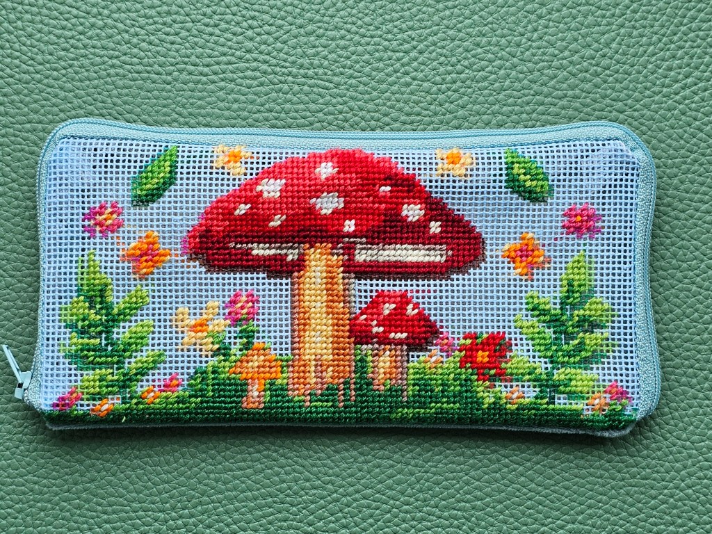 Nearly finished DIY zip case with a half stitch design featuring colourful mushrooms