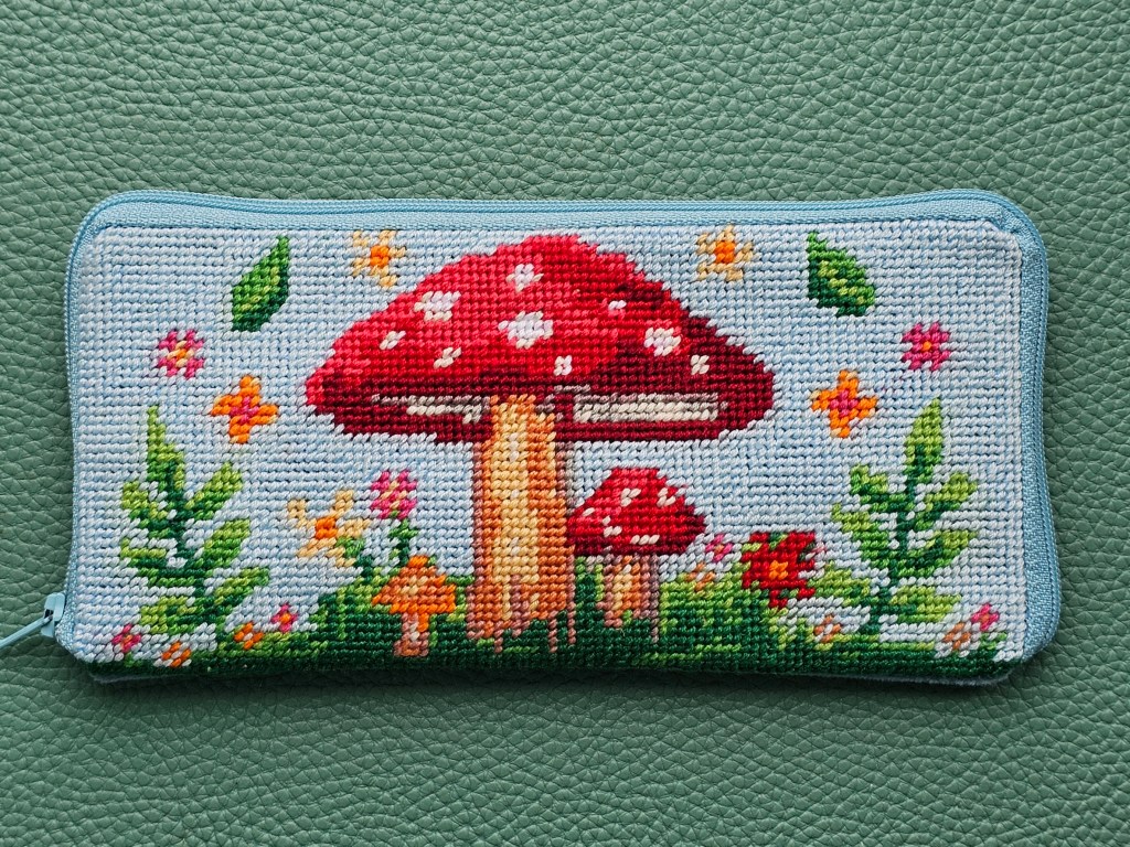 Finished DIY zip case with a half stitch design featuring colourful mushrooms