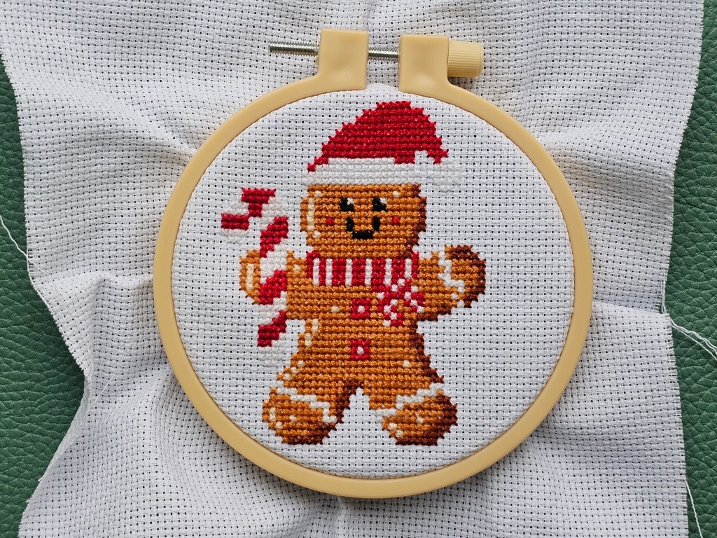 Finished mini cross stitch project featuring a gingerbread man.