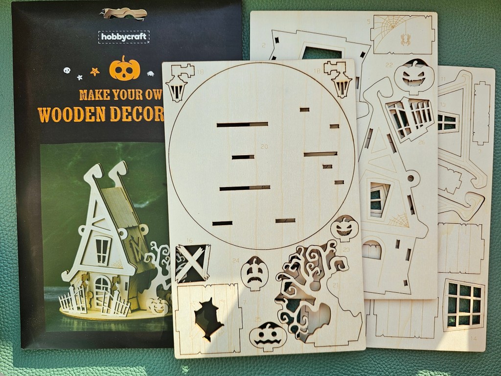 Contents of a DIY kit for making a wooden haunted house decoration
