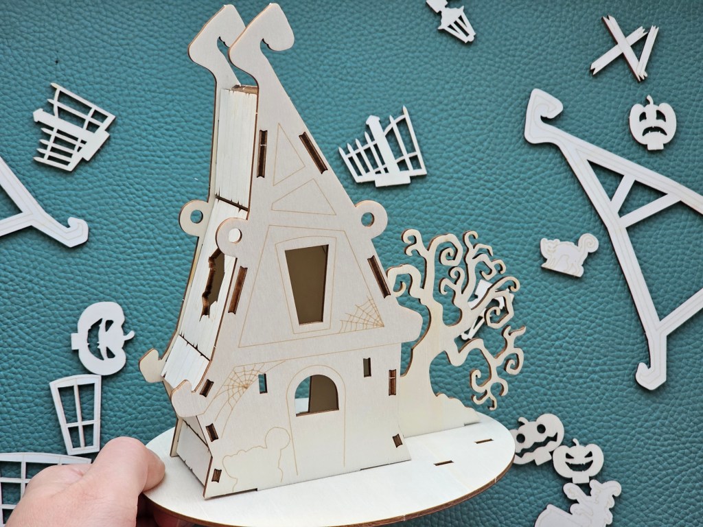 Partially assembled wooden haunted Halloween house. Other pieces are visible in the background.