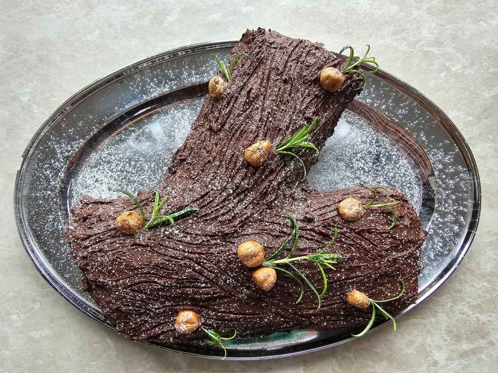 Hazelnut yule log cake on a silver platter