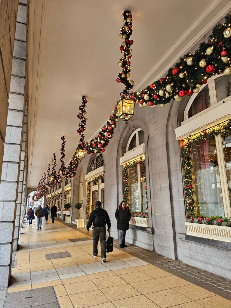 Christmas garlands with red and gold baubles hanging outside a posh hotel in London