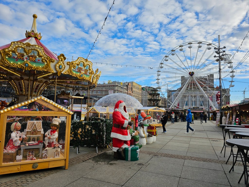A carousel and a Ferris wheel at a Christmas market