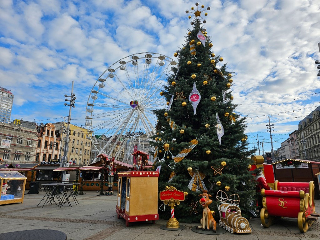A Christmas market, a giant Ferris wheel, and a Christmas tree.