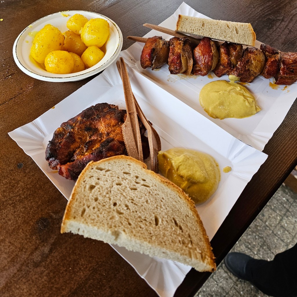 Paper plates with grilled pork chop and a meaty skewer