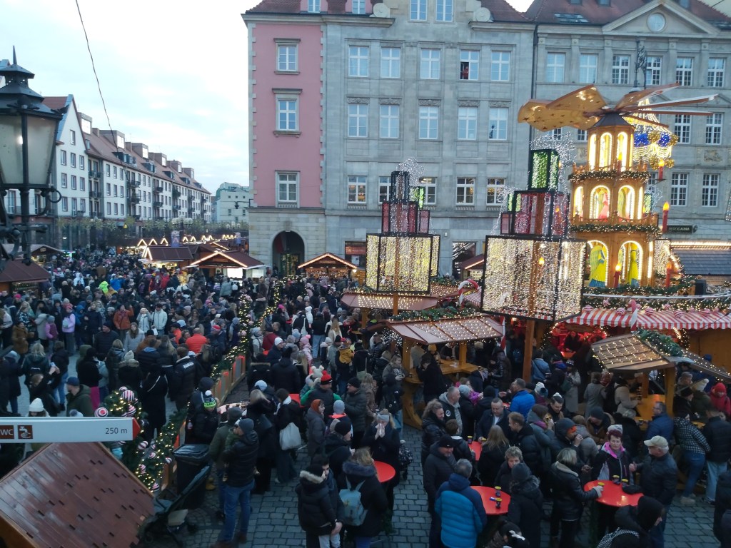 Wroclaw Christmas market by day. There are various stands and crowds of people