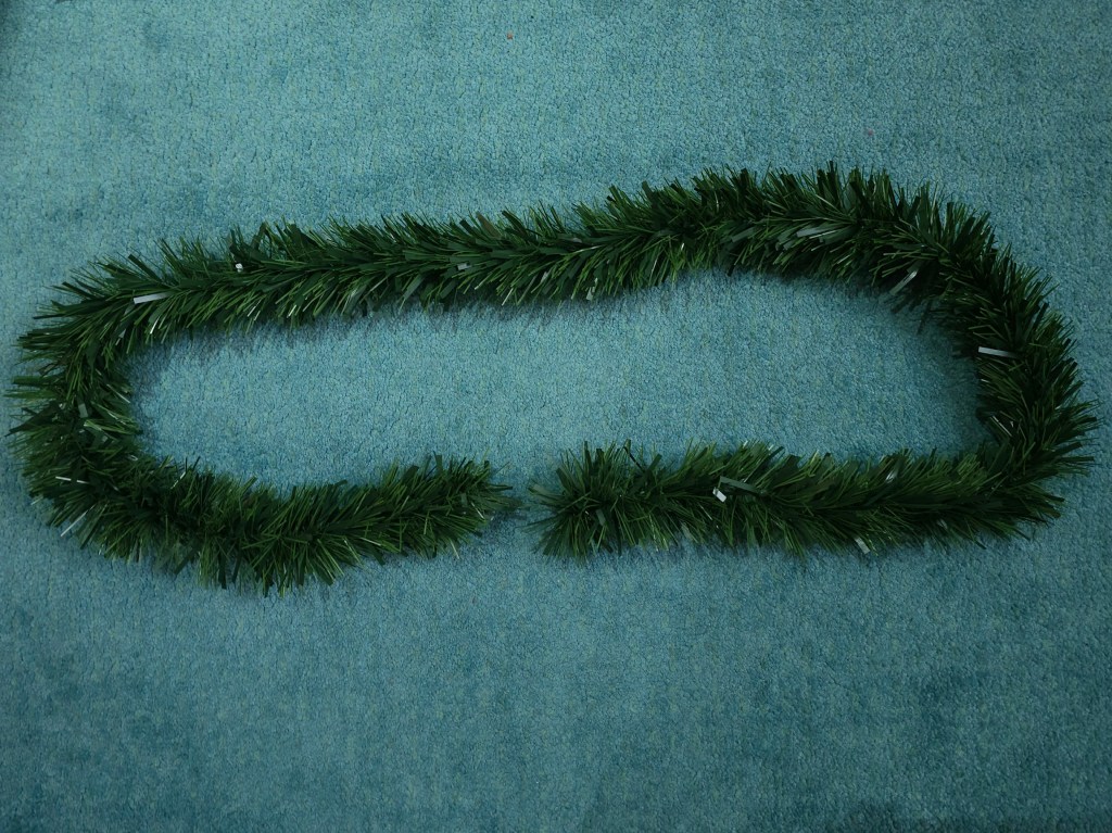 Green blank Christmas garland placed in a circle on the floor