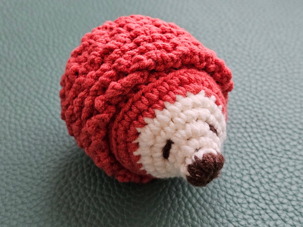 Nearly finished mini crocheted hedgehog. A couple of rows of spikes are missing.