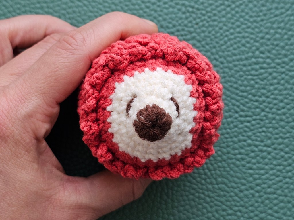 Finished mini crocheted hedgehog. A couple of rows of spikes are missing.