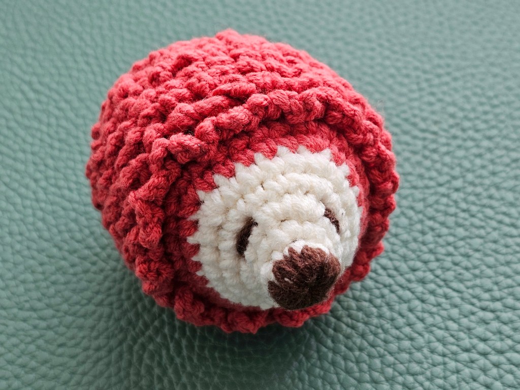 Finished mini crocheted hedgehog. A couple of rows of spikes are missing.