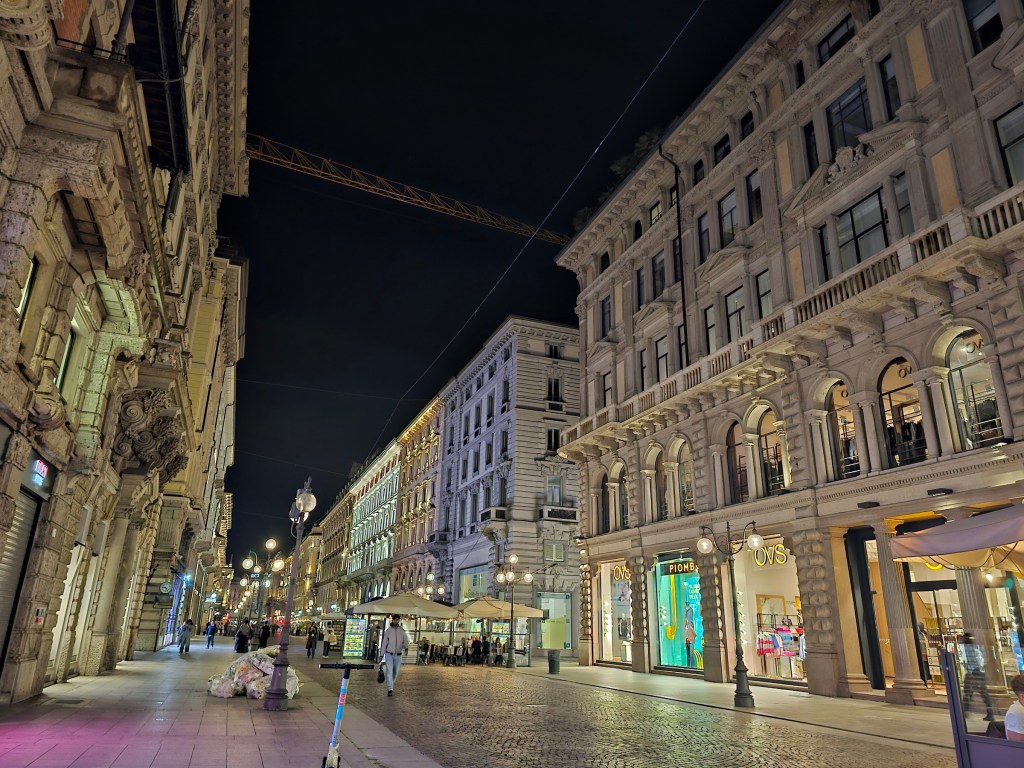 The centre of Milan, Italy, by night - a pedestrian street lined with majestic buildings