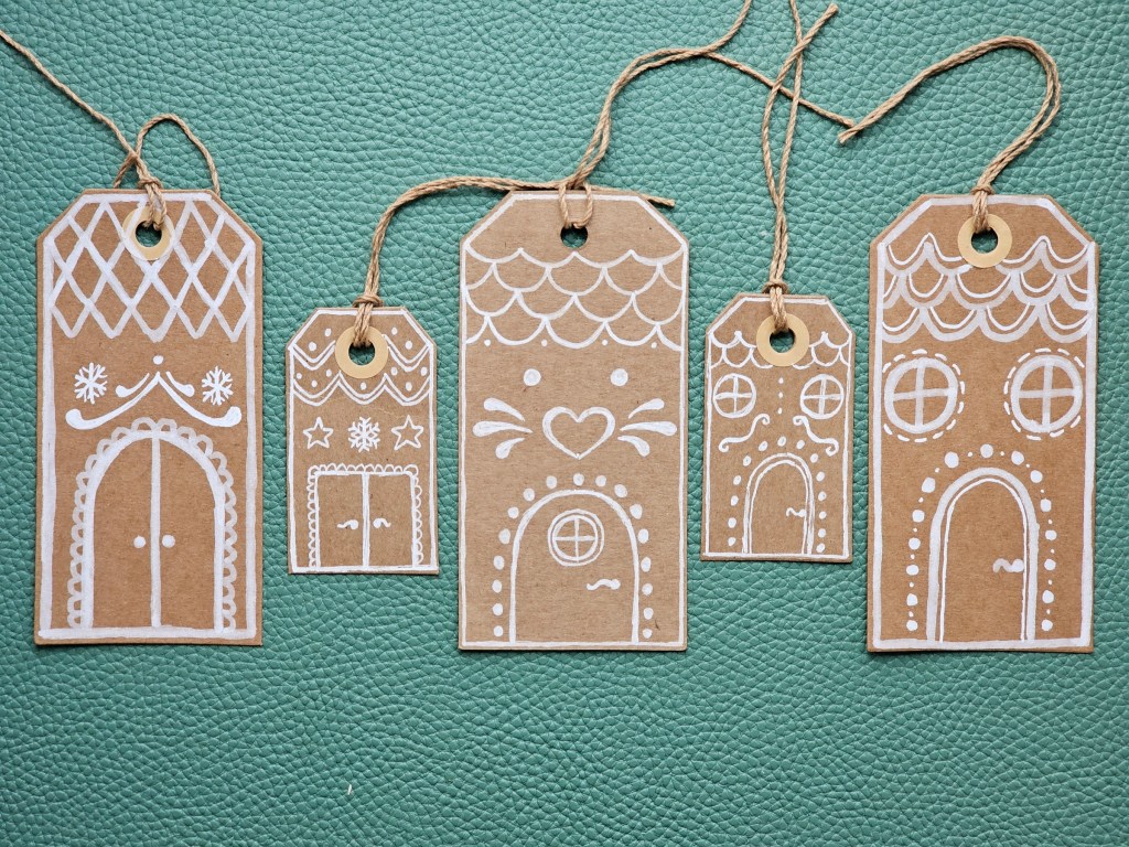 Plain brown rectangular gift tags in two shapes, with gingerbread houses drawn with white pen.