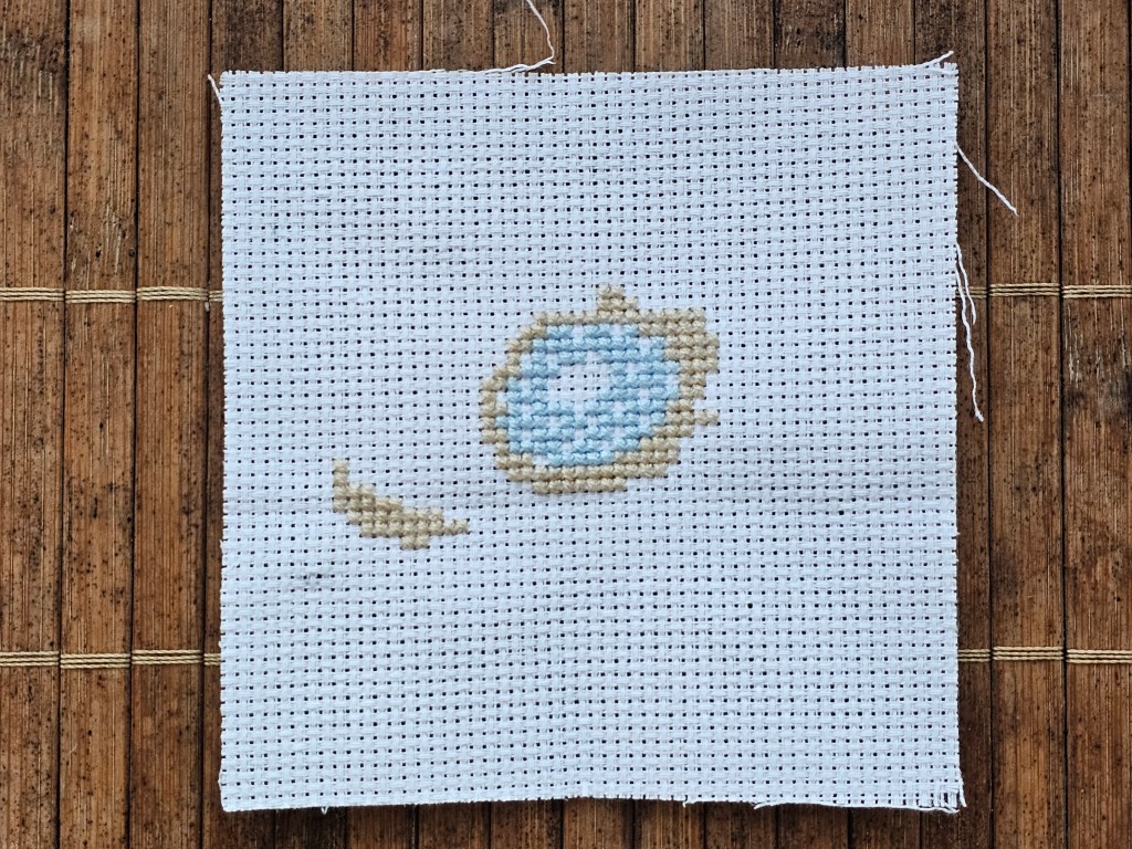Partially completed cross stitch anemone. Two colours are finished.
