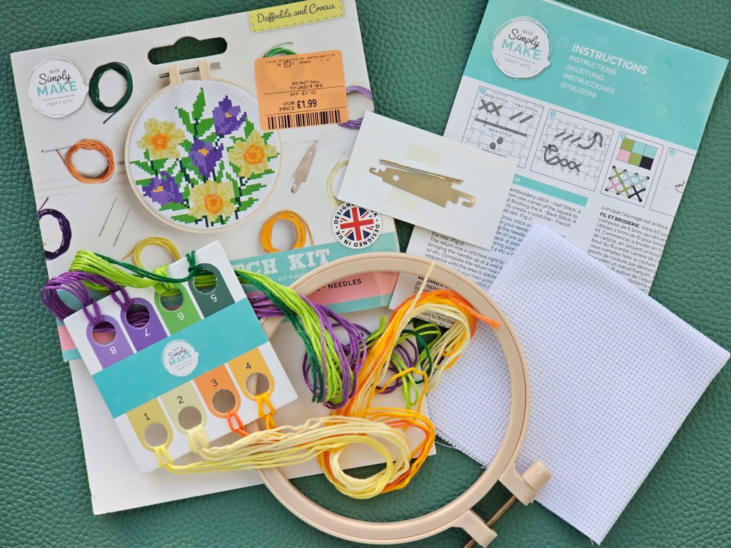 Contents of an assorted cross stitch set with a design featuring daffodils and crocuses.