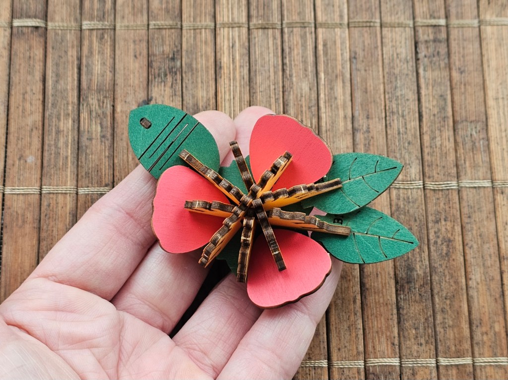 Partially assembled wooden red camellia flower