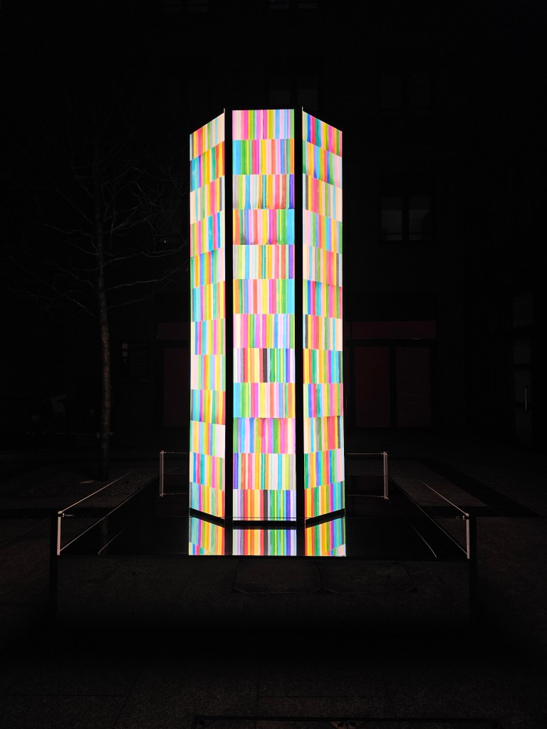 An illuminated pillar made of colourful blocks